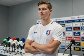Portrait d'un jeune footballeur français en conférence de presse, illustrant un article sur les origines et la famille de Matthis Abline