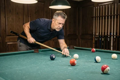 Joueur de billard analysant l'angle de tir sur une table professionnelle en feutrine verte