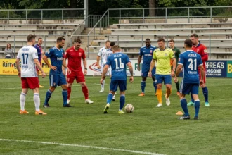 Groupe de joueurs de football amateurs sur un terrain municipal en France, illustrant le sport le plus pratiqué avec le plus de licenciés